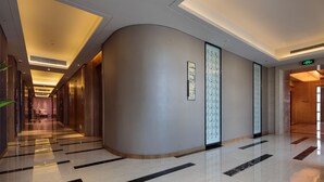 A modern hotel corridor with a curved wall, recessed lighting, and a polished floor. - Pullman Anshan Time Square (Anshan)