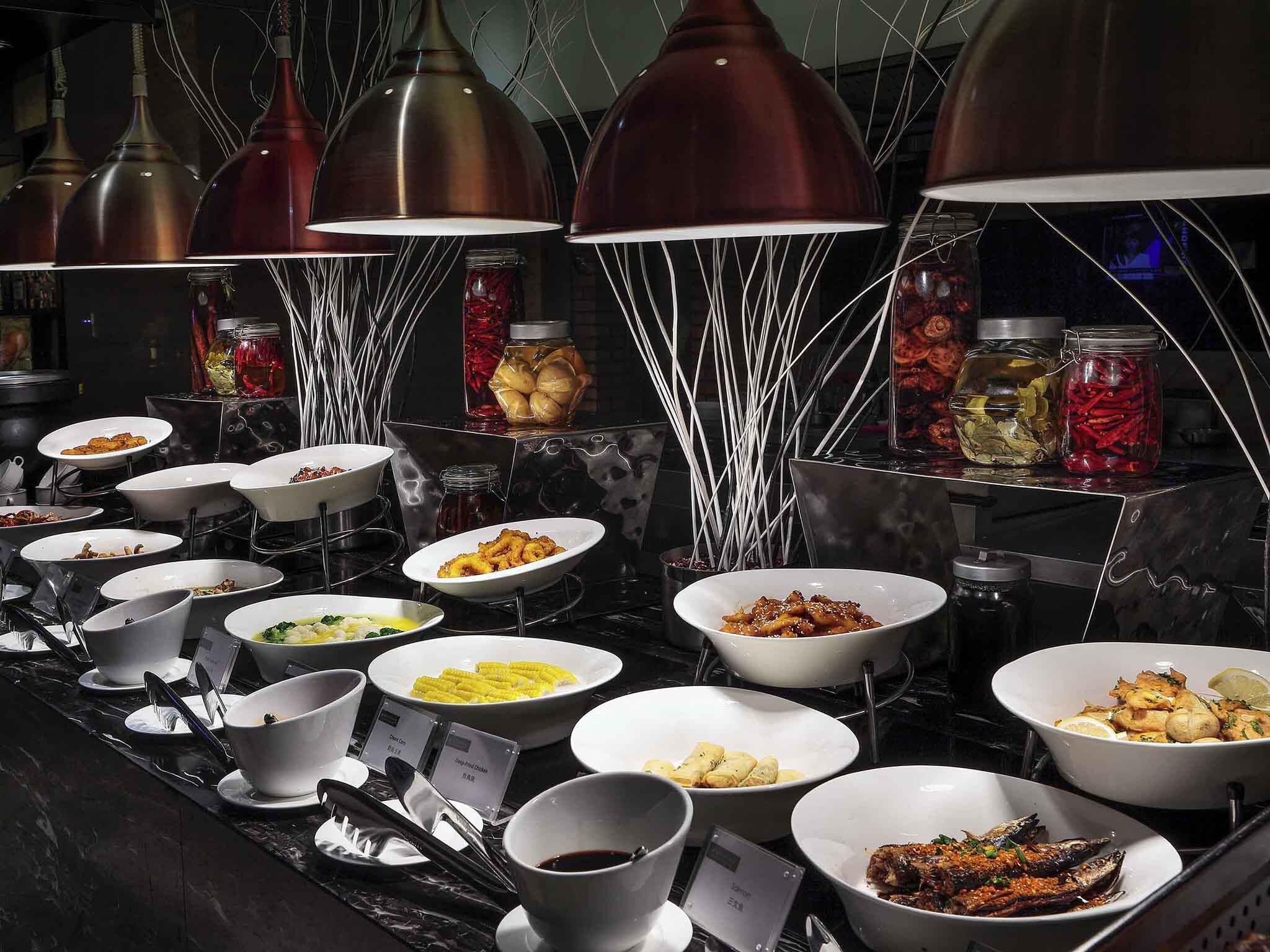 A buffet setup with various dishes and condiments.