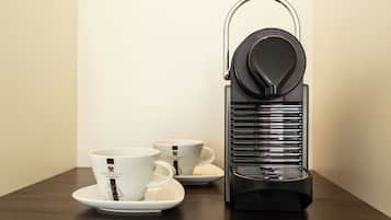 Une machine à café dotée d’un manche en métal et d’une base noire, posée sur une table en bois.