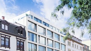 A modern building with multiple floors, large windows, and a mix of architectural styles.