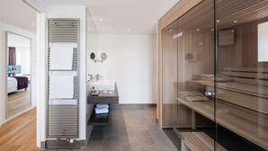 A modern bathroom with a glass shower enclosure, a wooden vanity, and a large mirror.
