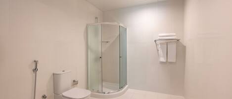 A modern bathroom with a glass-enclosed shower, a toilet, and a towel rack.