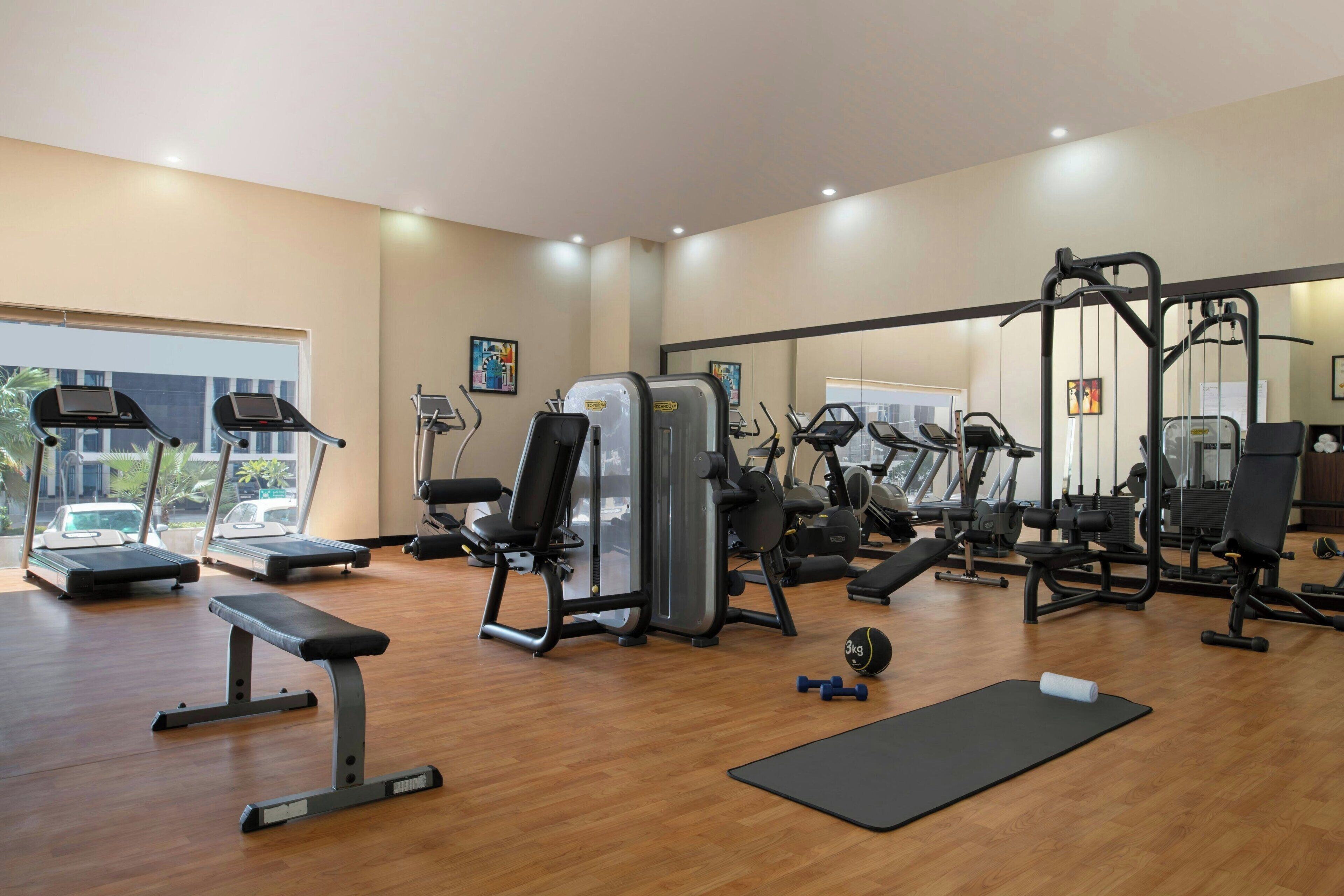 A gym with treadmills, weight machines, and benches.