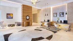 A modern reception area with a checkered floor, a wooden accent wall, and a chandelier. - Marriott Executive Apartments City Center Doha (Doha)