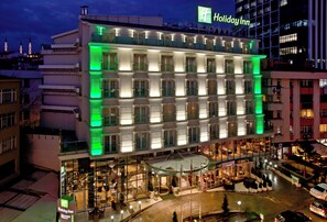 A multi-story Holiday Inn hotel with a ground-level restaurant and outdoor seating. - Holiday Inn Ankara - Kavaklidere by IHG (Ankara)