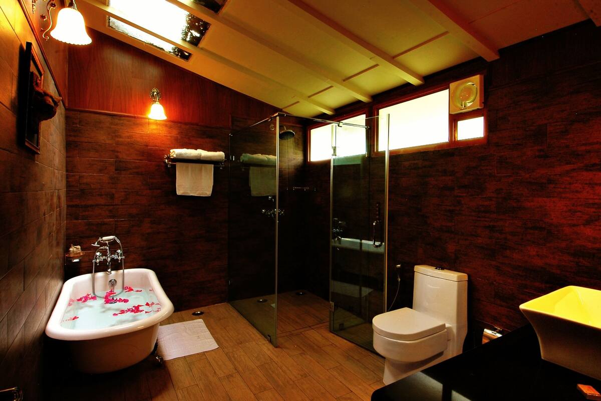 A bathroom with a bathtub, toilet, and glass-enclosed shower.