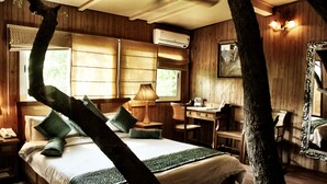 A wooden-themed bedroom with a bed, desk, and chair. - The Tree House Resort (Amer)