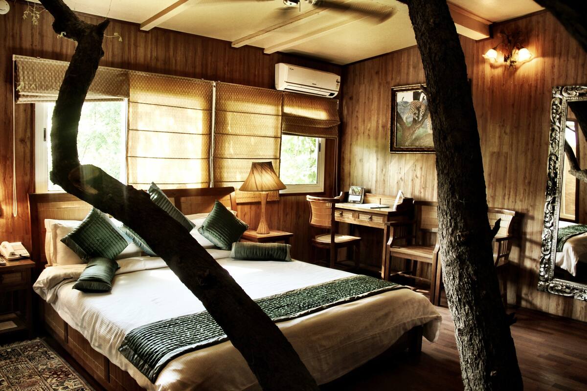 A wooden-themed bedroom with a bed, desk, and chair.