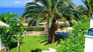 Un jardin bien entretenu, agrémenté de palmiers et offrant une vue dégagée sur l’océan.