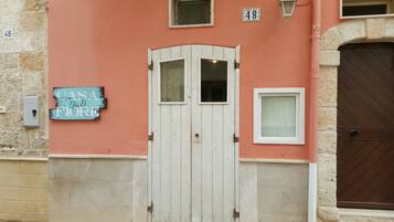 A building with a white door, a sign reading "Casa B&F", and a number "48" on the wall.