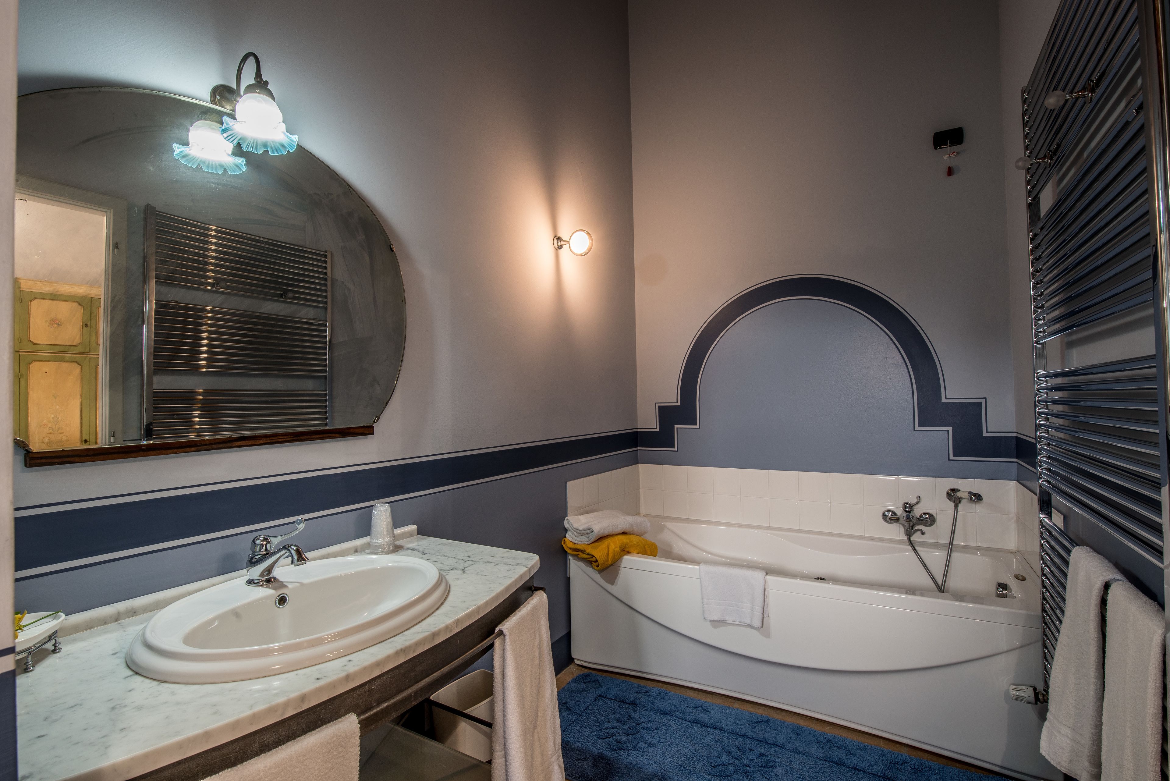 A bathroom with a sink, mirror, and bathtub.