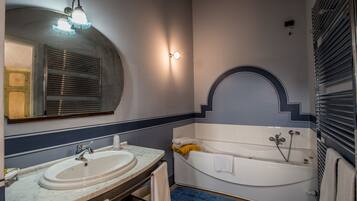 A bathroom with a sink, mirror, and bathtub.