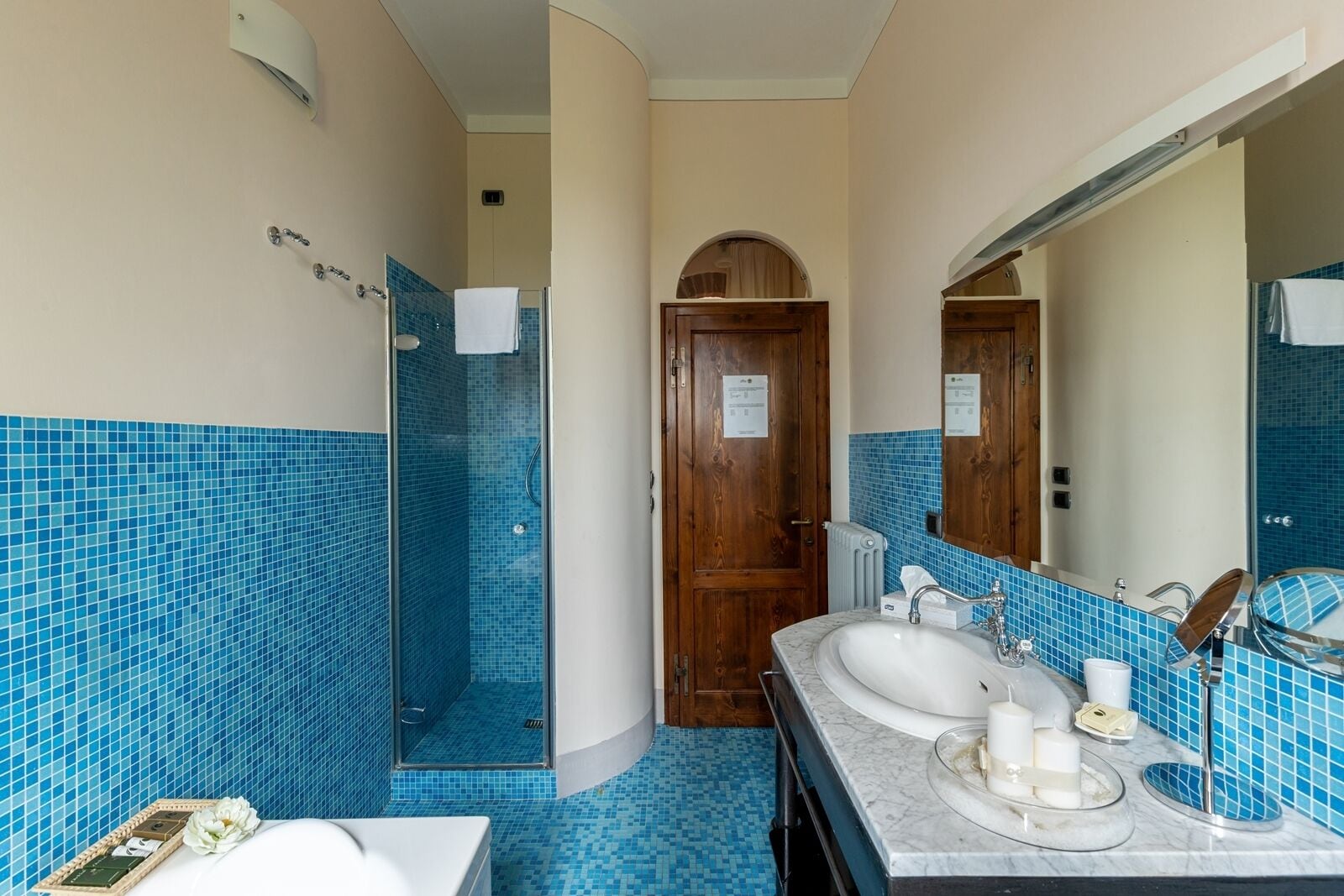 A bathroom with a shower, two sinks, and a large mirror.