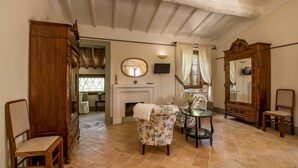 A traditional room with a fireplace, wooden furniture, and a large mirror. - Podere La Rocca (Montepulciano)