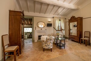 Una habitación tradicional con chimenea, muebles de madera y un espejo grande.