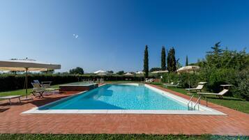 Alberca al aire libre y camastros