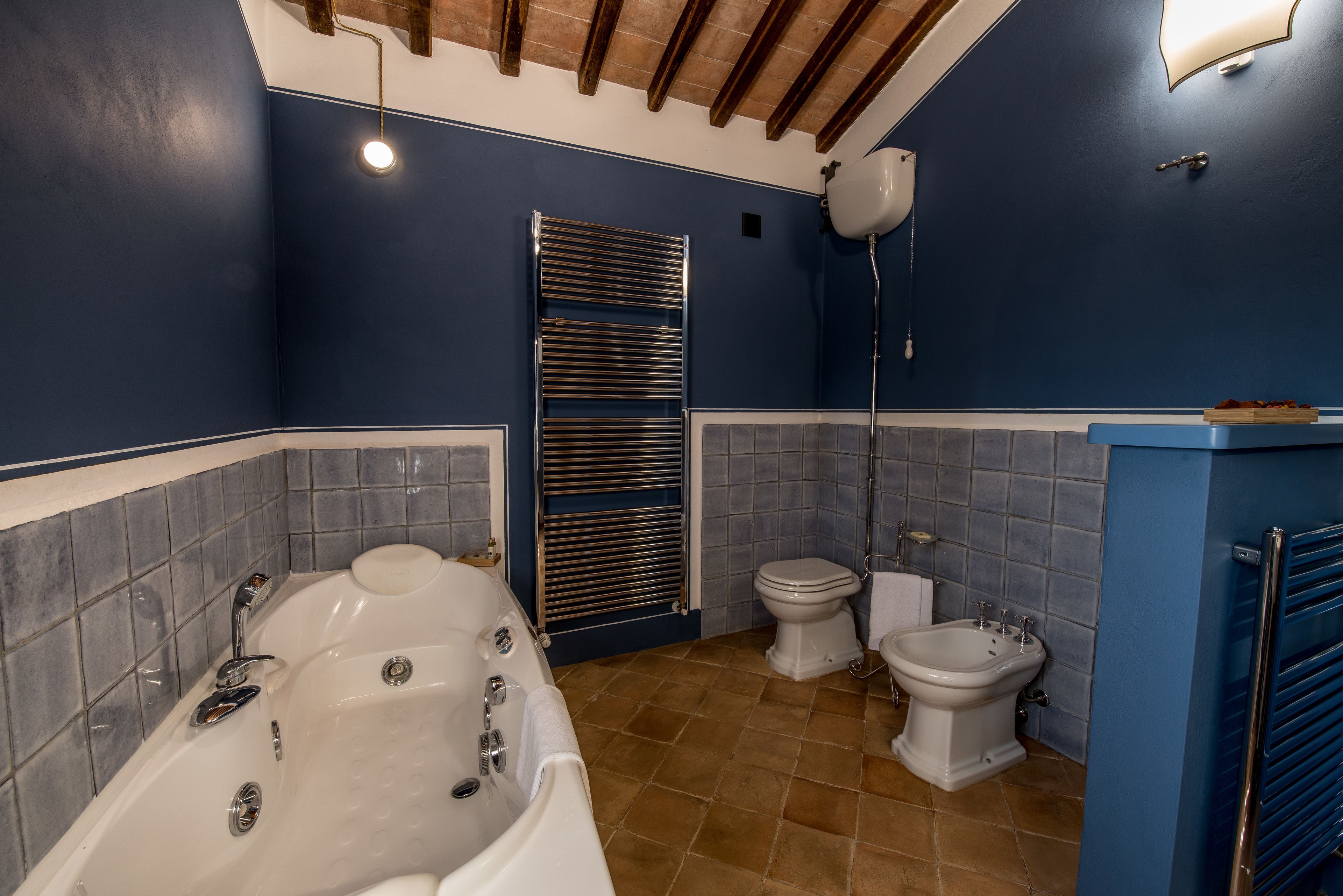 A bathroom with a bathtub, toilet, and bidet.
