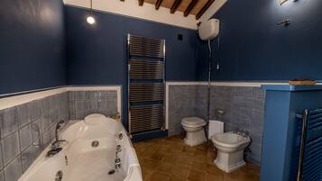 A bathroom with a bathtub, toilet, and bidet.
