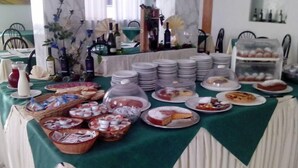 A buffet table with various food items, plates, and condiments. - Hotel Quisisana (Chianciano Terme)