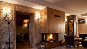 Una sala de estar acogedora con chimenea, paneles de madera y un espacio de descanso cómodo.