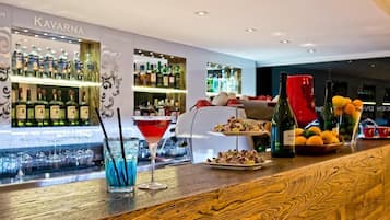 A bar area with a variety of liquor bottles, a martini glass, and a tray of snacks.