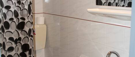 A bathroom with a toilet, sink, and a mirror above the sink.