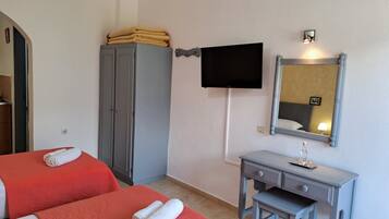 Habitación de hotel con dos camas, un armario, un escritorio, un espejo y un televisor.