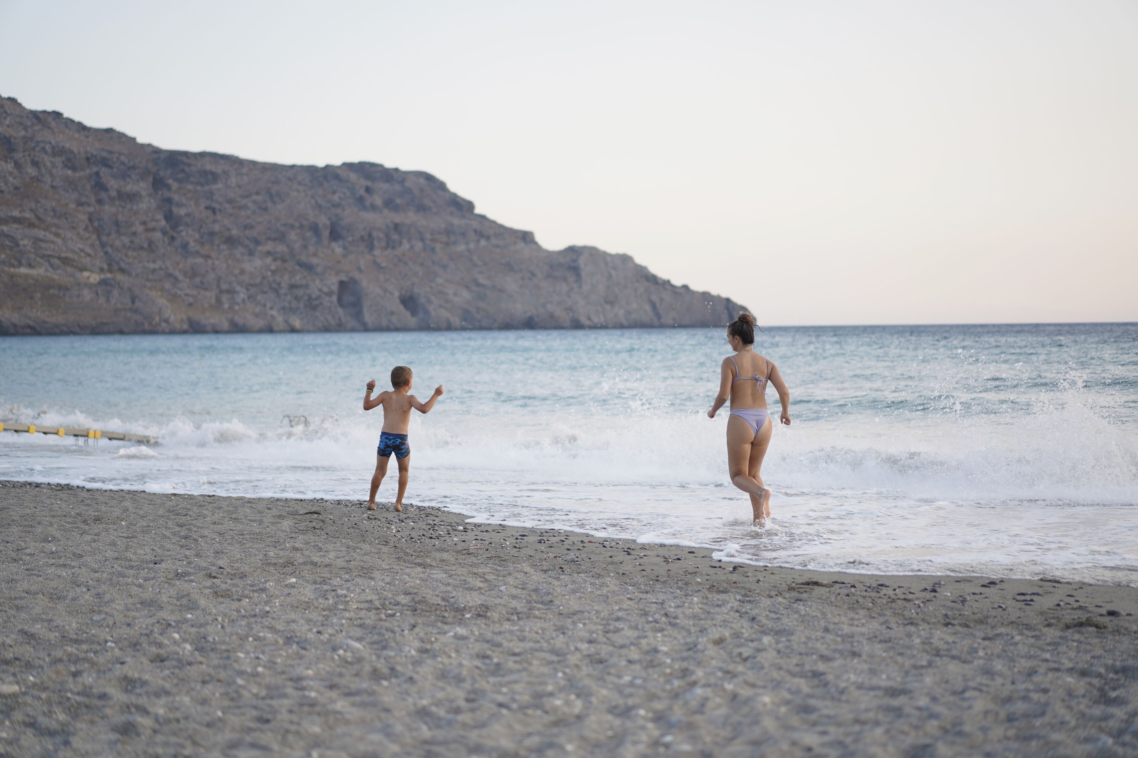 A beach with rocky cliffs in the background.