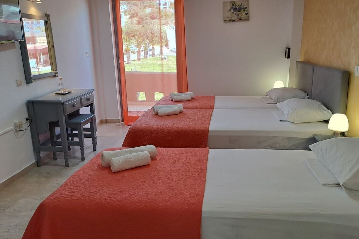 Una habitación de hotel con dos camas, un escritorio y una silla.
