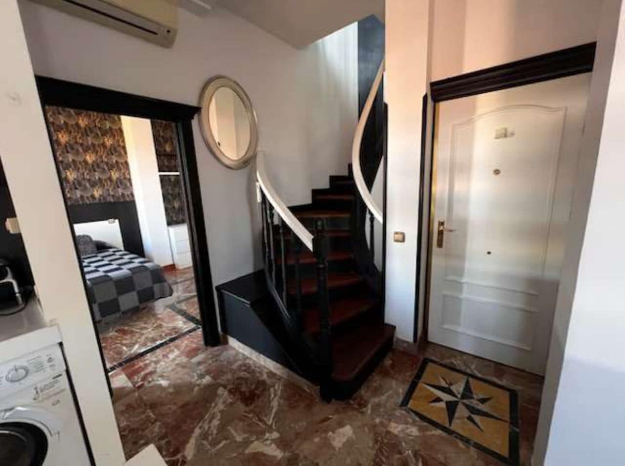 A staircase leading to a bedroom with a checkered bedspread.