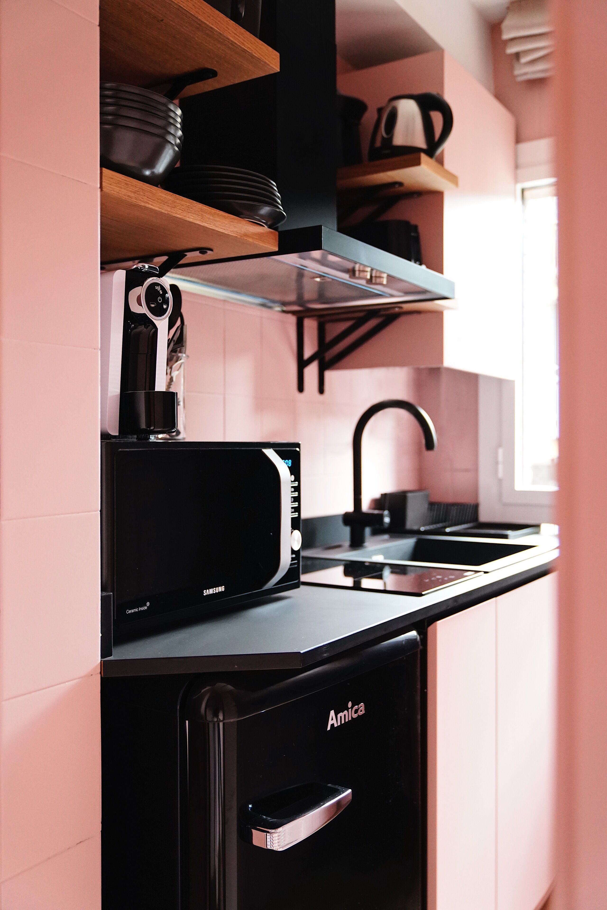 A compact kitchen with a microwave, toaster, and sink.