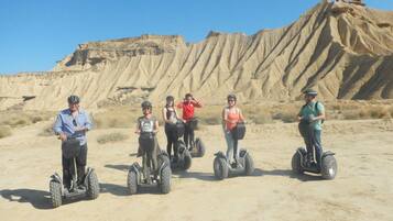 Un grupo de personas en Segways en un paisaje desértico con acantilados rocosos.