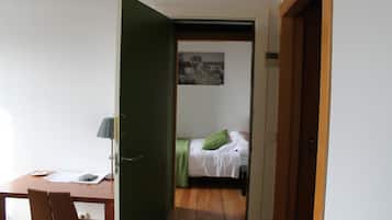 Una habitación con cama, escritorio y silla.