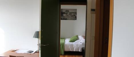 Una habitación con cama, escritorio y silla.