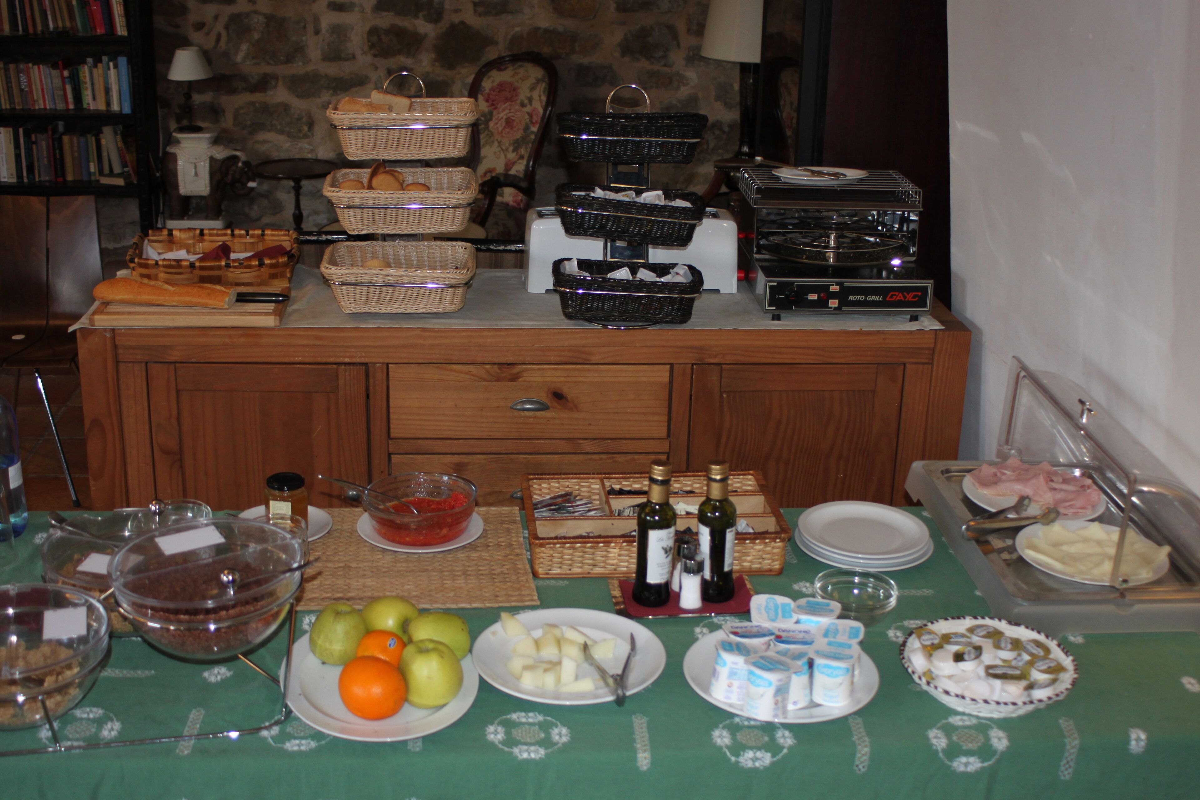 Una mesa de buffet con diversos alimentos, cestas y un tostador.