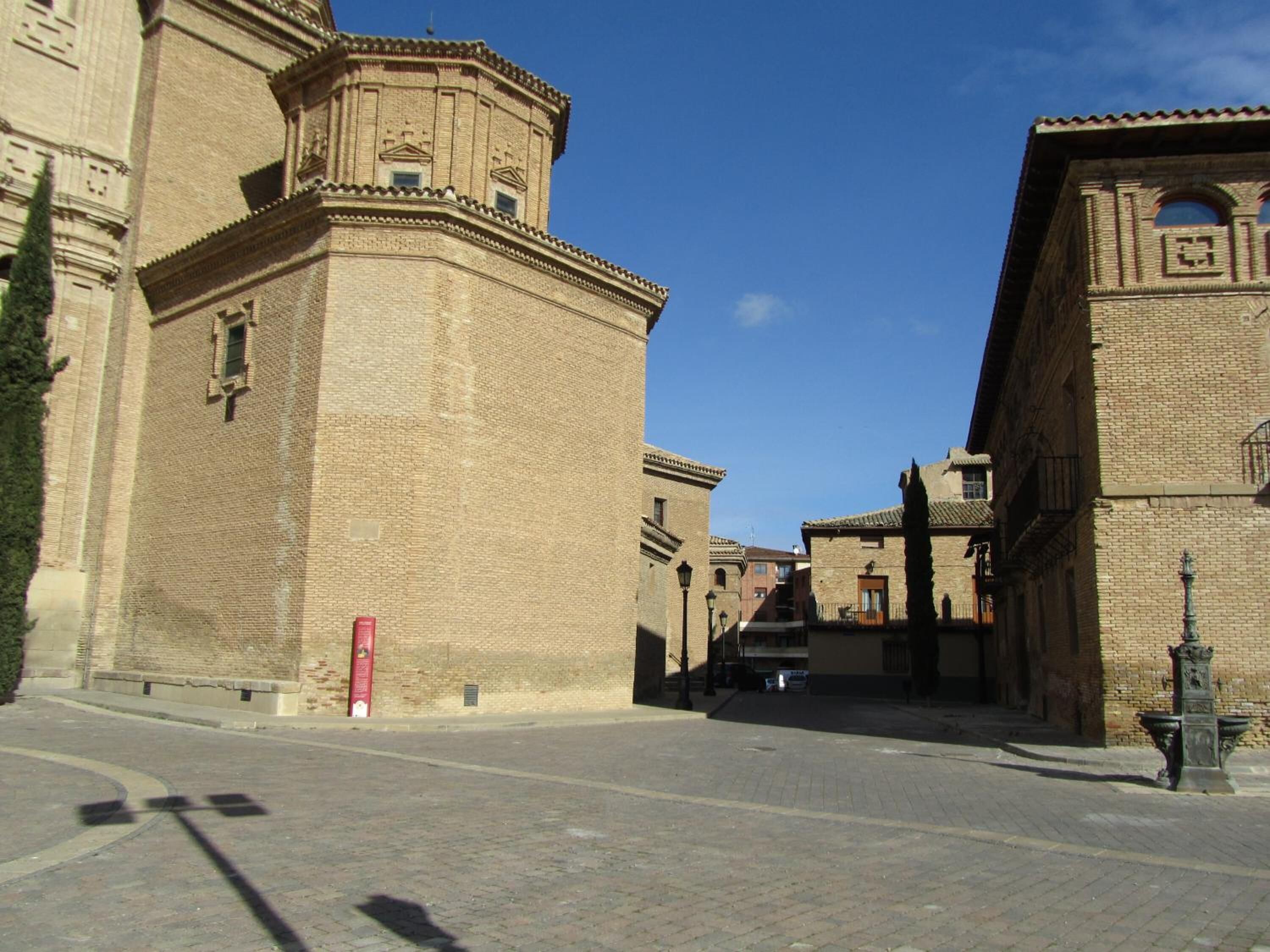 Una calle histórica con edificios de ladrillo tradicionales, cielo despejado y camino pavimentado.