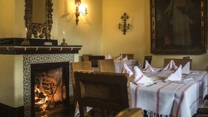 A dining room with a fireplace, ornate mirror, and a large painting on the wall. - Hotel Museo Mayan Inn de Guatemala (Chichicastenango)