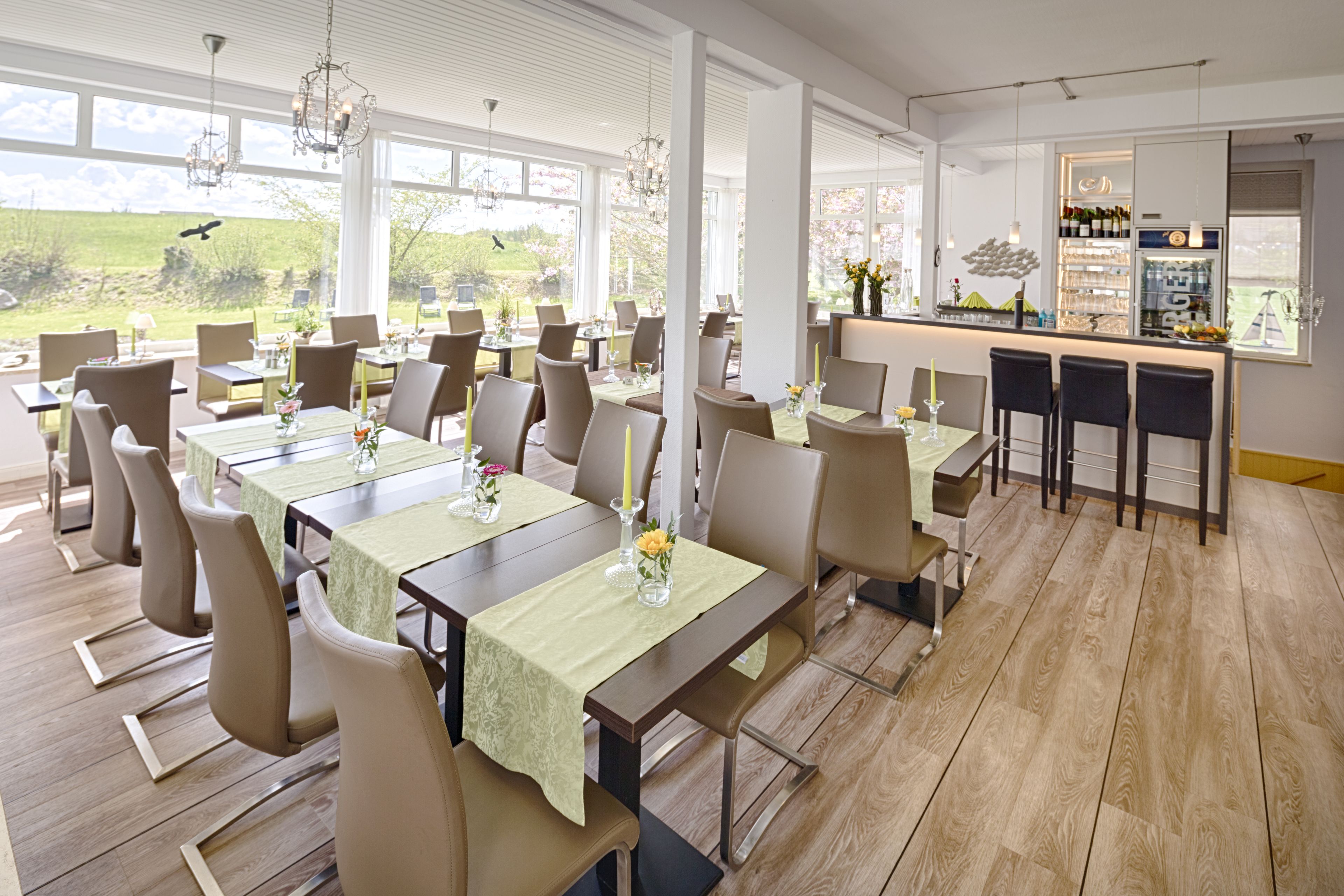 Un espace repas comprenant plusieurs tables, des chaises et un bar.