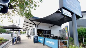A coffee house and apartment motel with outdoor seating and a shaded area. - Coffee House Apartment Motel (Rockhampton)