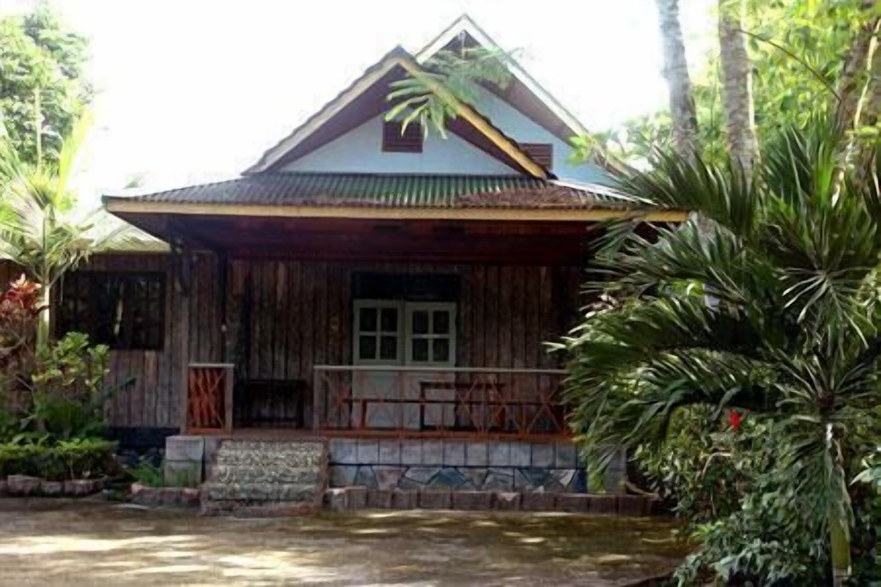 A rustic wooden house with a pitched roof and a porch.