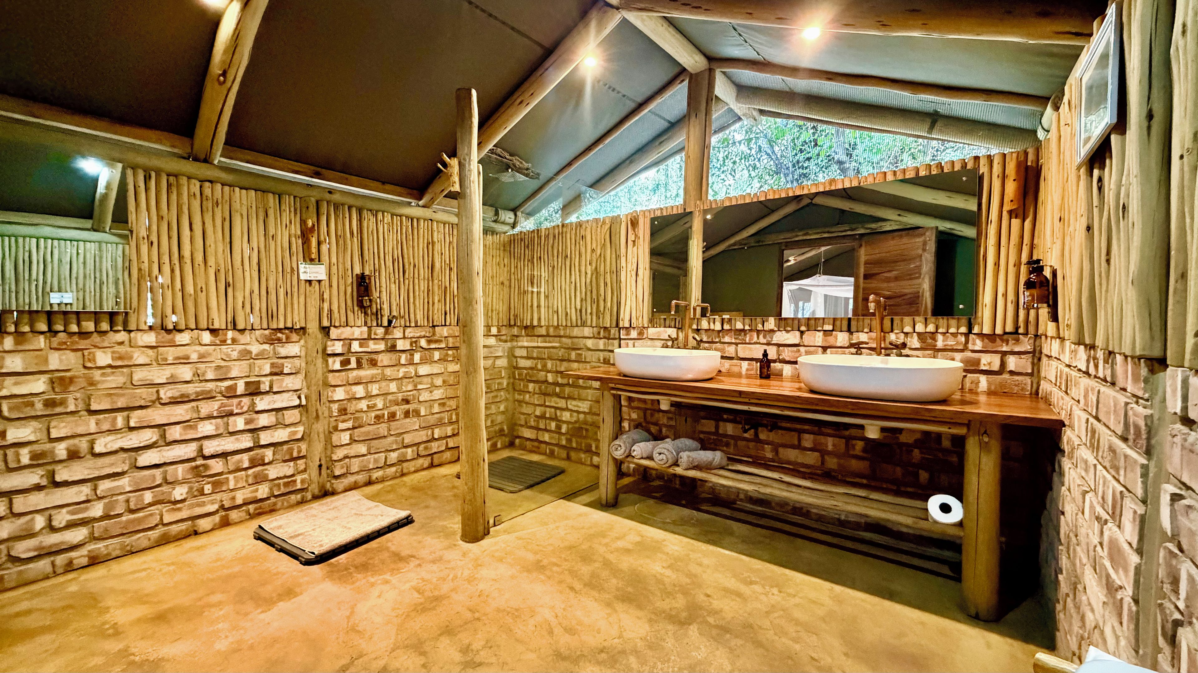 Une salle de bain rustique avec un grand mur en bois, un mur en pierre et un plafond en bois.