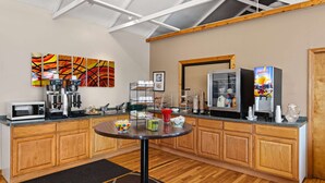 A kitchen with wooden cabinets, a microwave, coffee maker, and a refrigerator. - Super 8 by Wyndham Branson / Shepherd of the Hills Exwy (Branson)