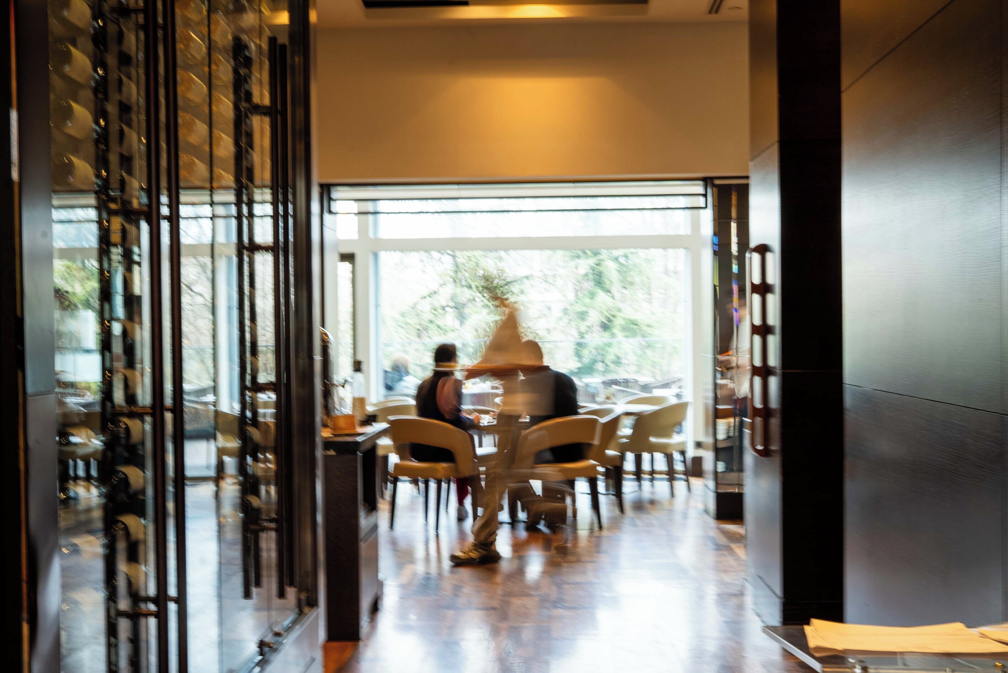 Un intérieur moderne avec un coin repas, de grandes fenêtres et un plancher en bois.