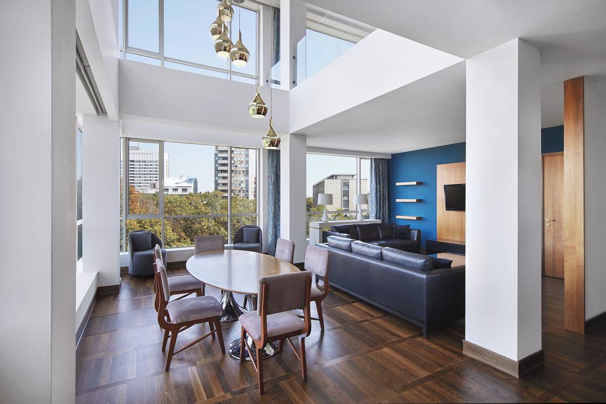 A spacious living area with a dining table, chairs, and a sofa.