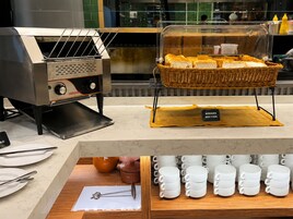 Un présentoir de boulangerie avec des paniers à pain et un coin café avec des tasses.
