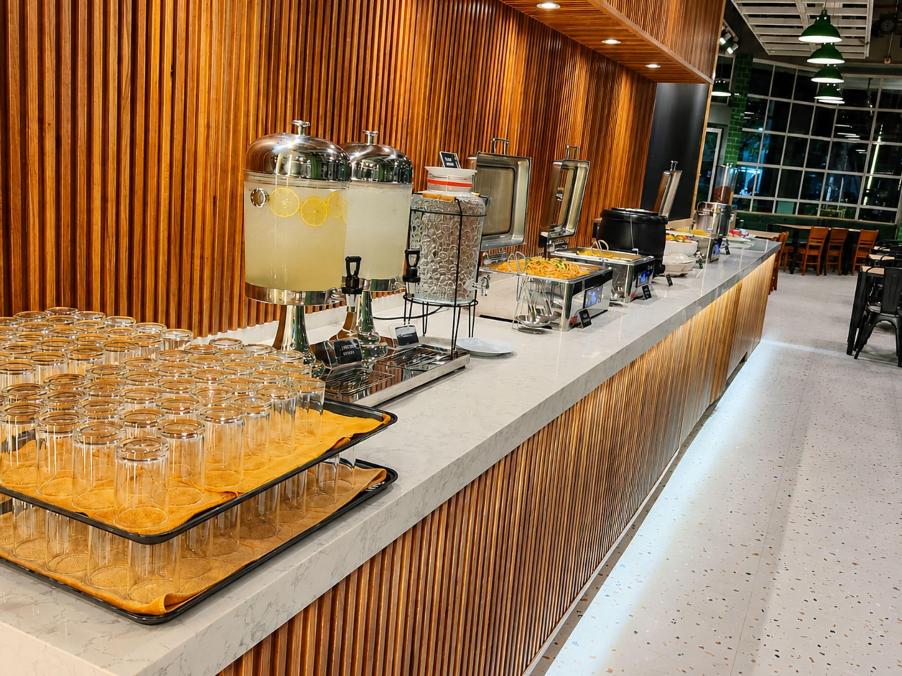 A buffet setup with various food stations and drink dispensers.