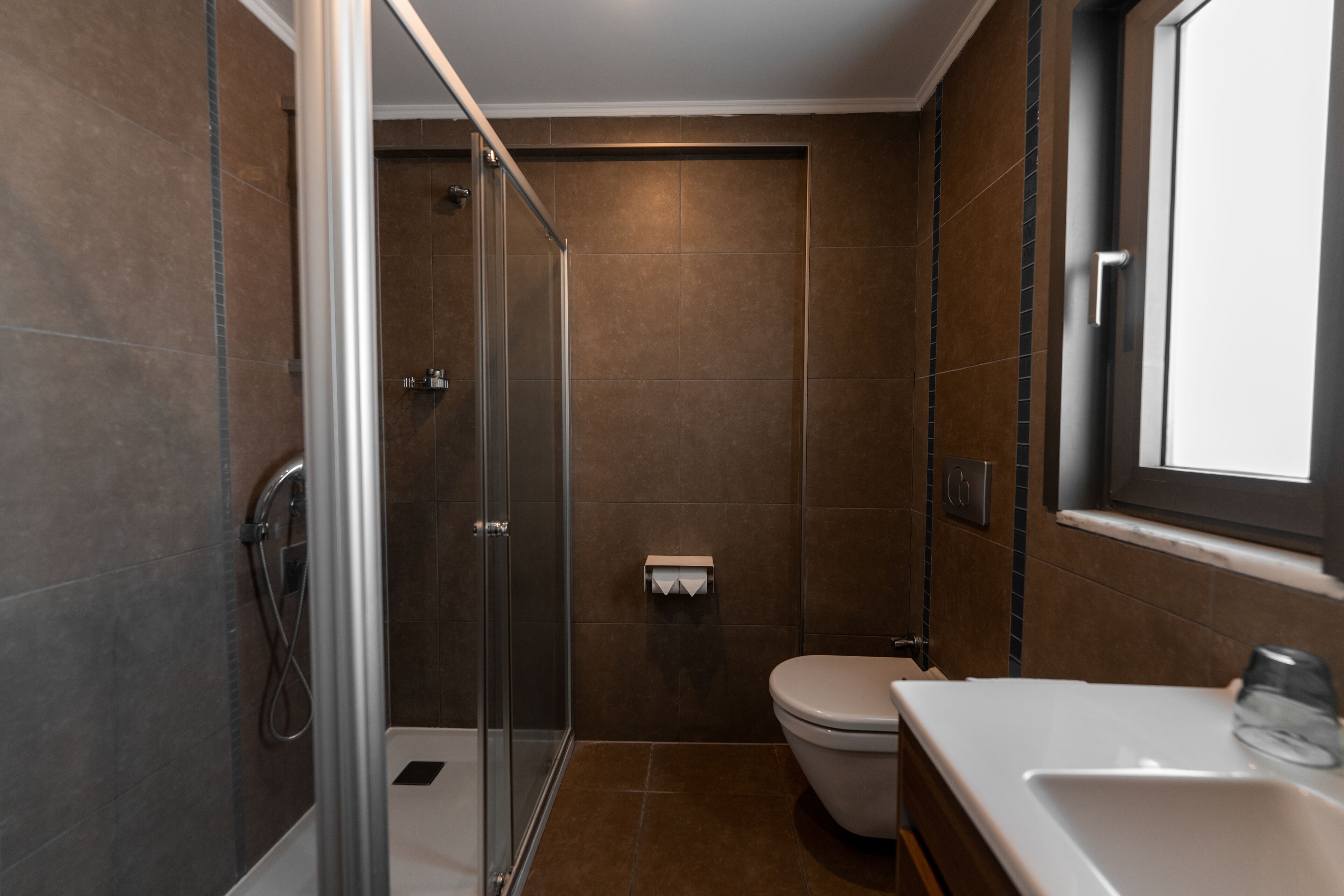 Une salle de bain moderne avec une douche à parois de verre, des toilettes et un lavabo.