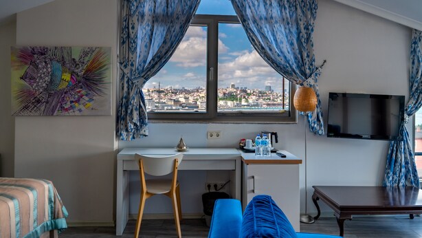 Una habitación moderna con escritorio, silla y un ventanal con cortinas.