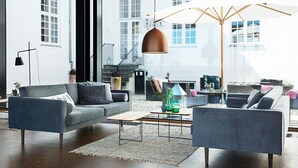 A modern living room with a sofa, armchairs, a coffee table, and a pendant light. - Rungstedgaard (Rungsted Kyst)