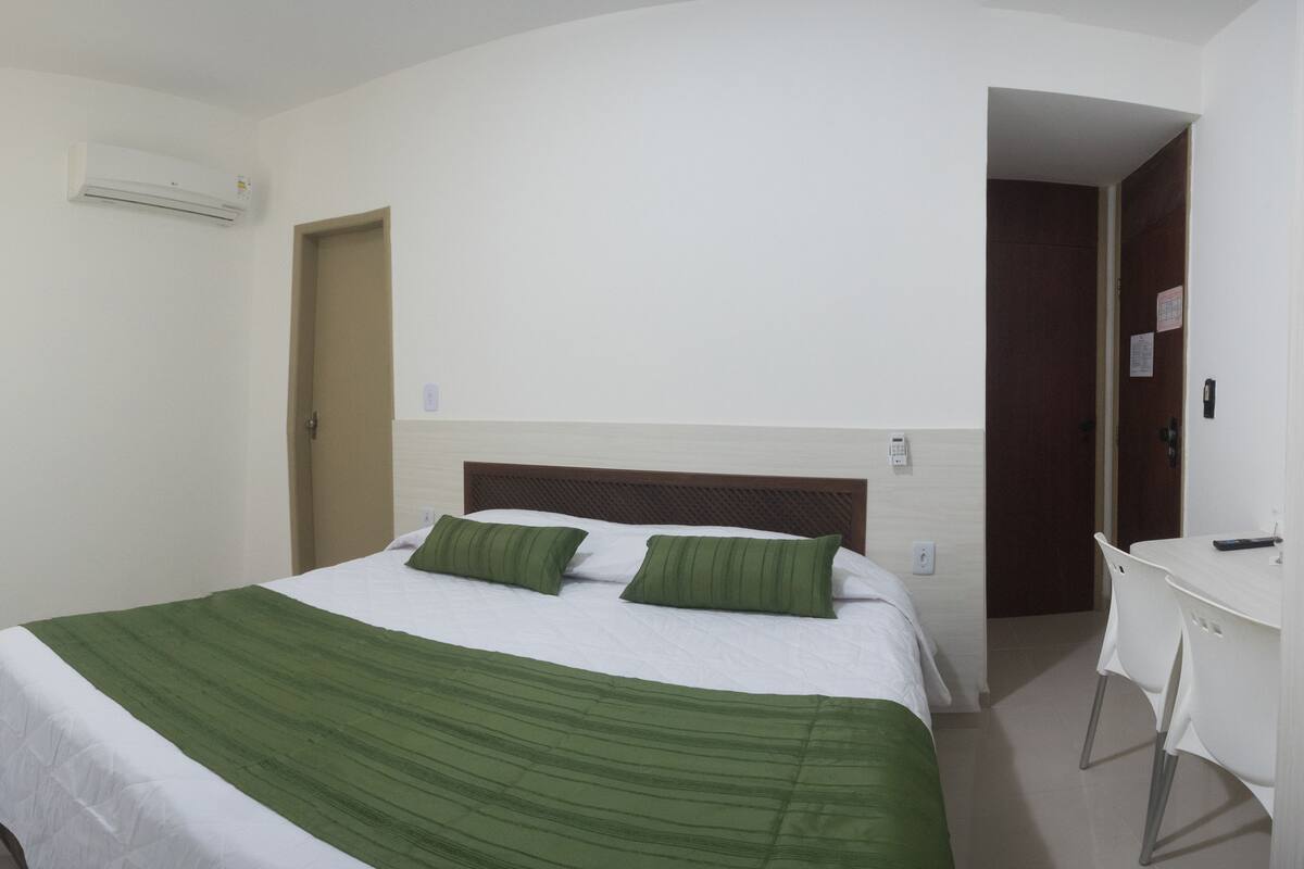 Une chambre d’hôtel avec un lit, un bureau et une porte.